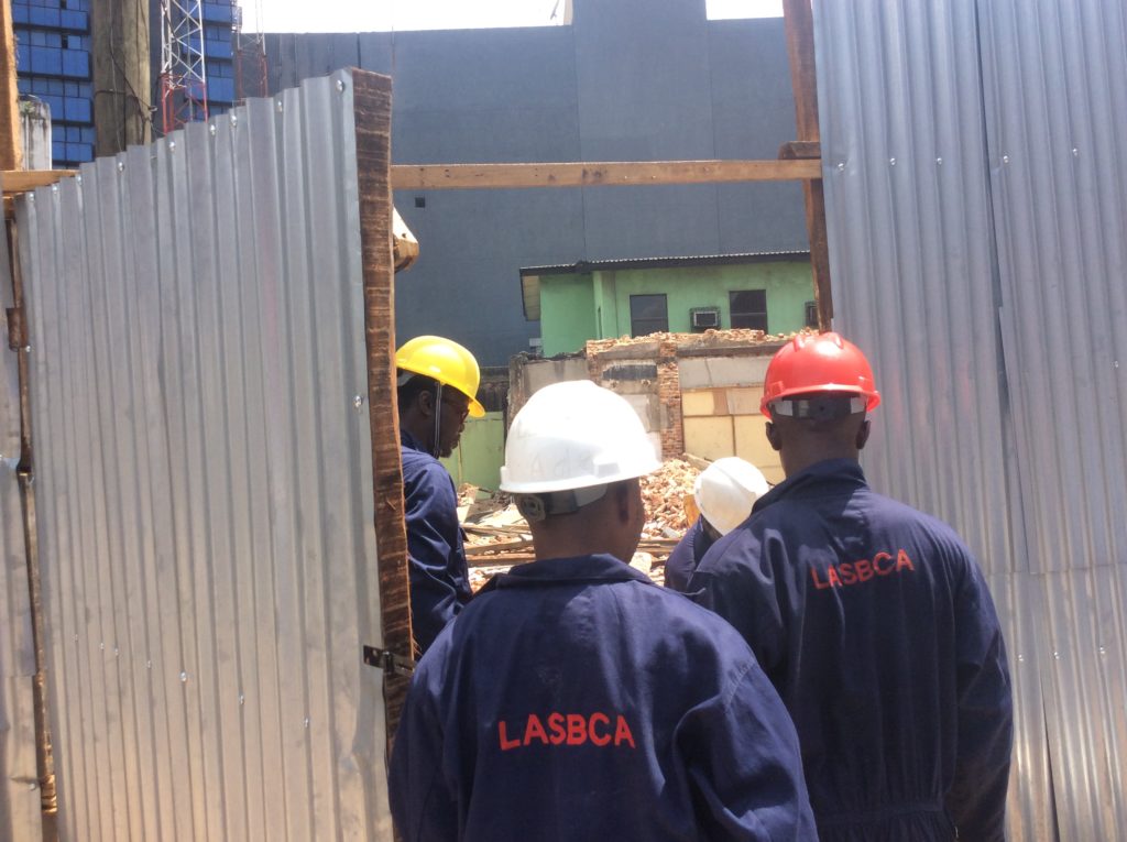 Men of the Lagos State Building Control Agency demolishing an illegal fencing on Sunday, September 18.